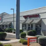 A plain retail store painting job on a grey exterior building with a drive-thru sign in front