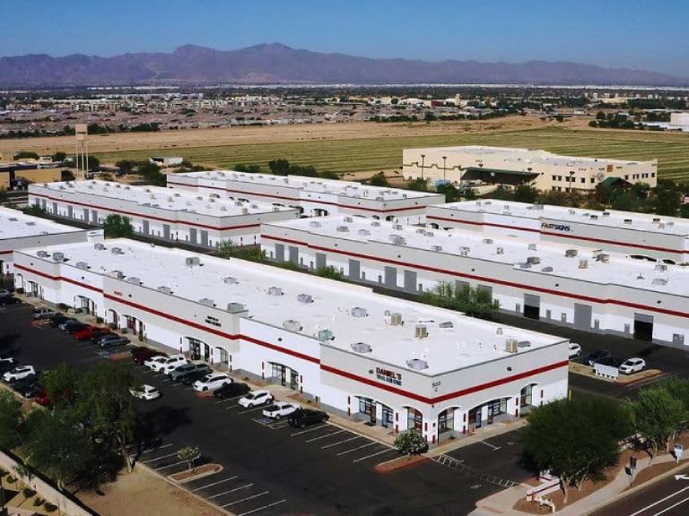 Aerial view of a fresh commercial painting job on retail strip mall buildings near mountains