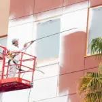 Ghaster painter using spray paint to paint the side of a building.