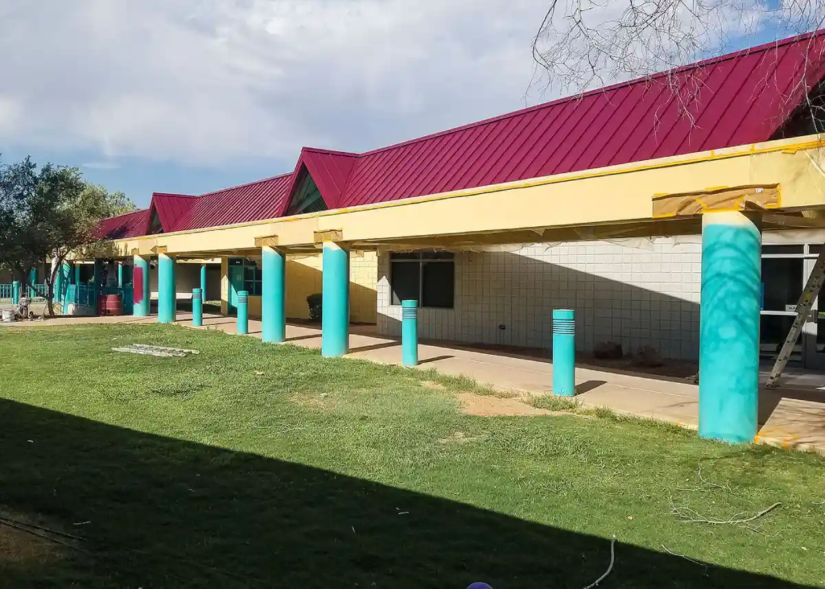Exterior view of a building with freshly applied paint, showcasing a modern color scheme that highlights architectural details.