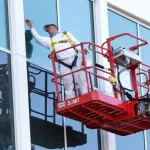 Painter working on painting the exterior of a building.
