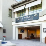 Exterior view of the '19th Hole Grill and Patio' building on a sunny day.