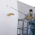 man roller painting the wall