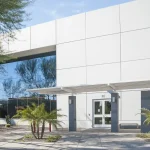 A modern glass building, showcasing its newly painted exterior, combining sleek glass surfaces with fresh, contemporary paint.