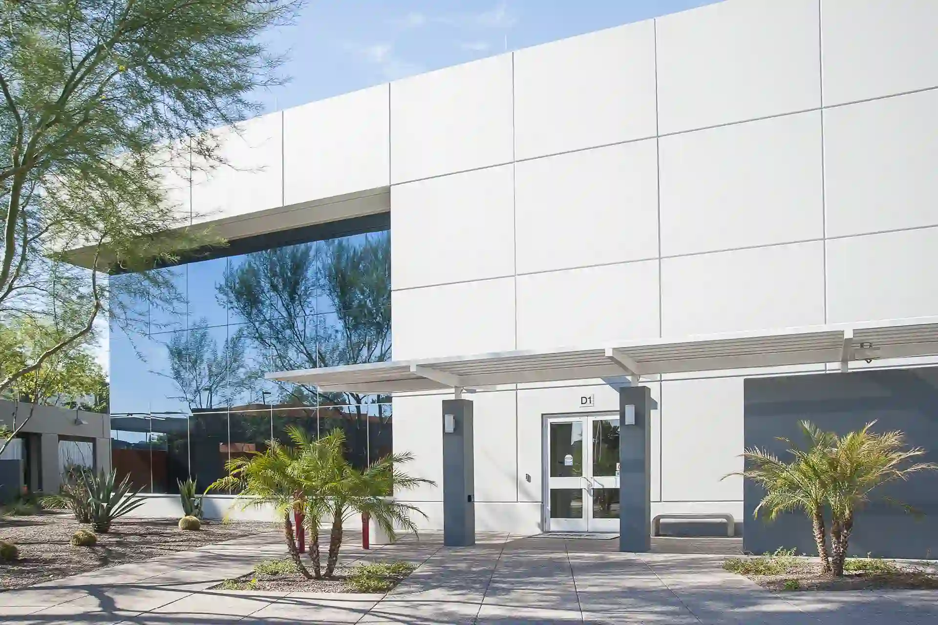 A modern glass building, showcasing its newly painted exterior, combining sleek glass surfaces with fresh, contemporary paint.