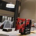 Inside a commercial building, painters setting up their machine lift to paint, highlighting their equipment and professional approach to the job.