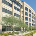 A commercial building with large, clear glass windows reflecting daylight, showcasing modern architectural design.
