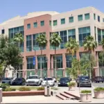 Commercial building w/ cars parked in front of the building