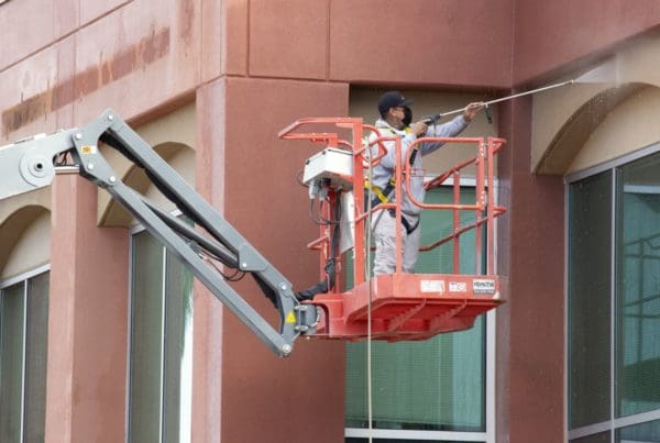 guy pressure washing a building