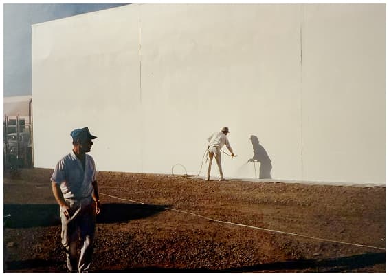 Historical exterior painting project showing workers spray painting commercial building