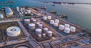 Industrial exterior painting of oil storage tanks at port facility