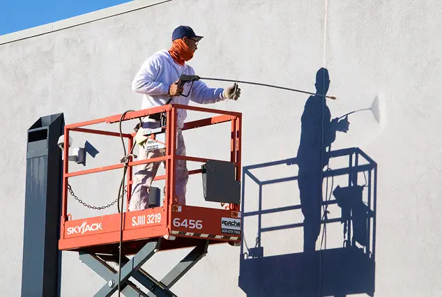 Commercial exterior building painting and pressure washing service using lift equipment