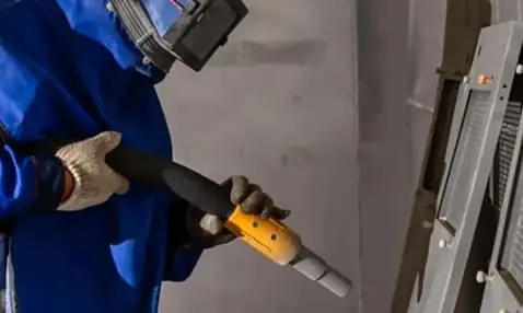 Worker performing sandblasting surface prep on metal structure