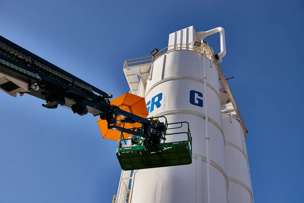 Industrial silo exterior painting using boom lift