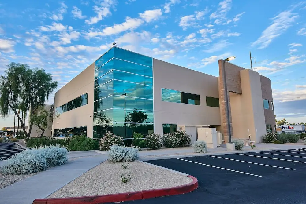 Contemporary office building exterior with reflective glass and desert landscaping
