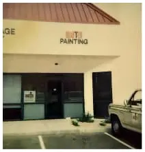 Painter in action using roller brush on commercial property exterior