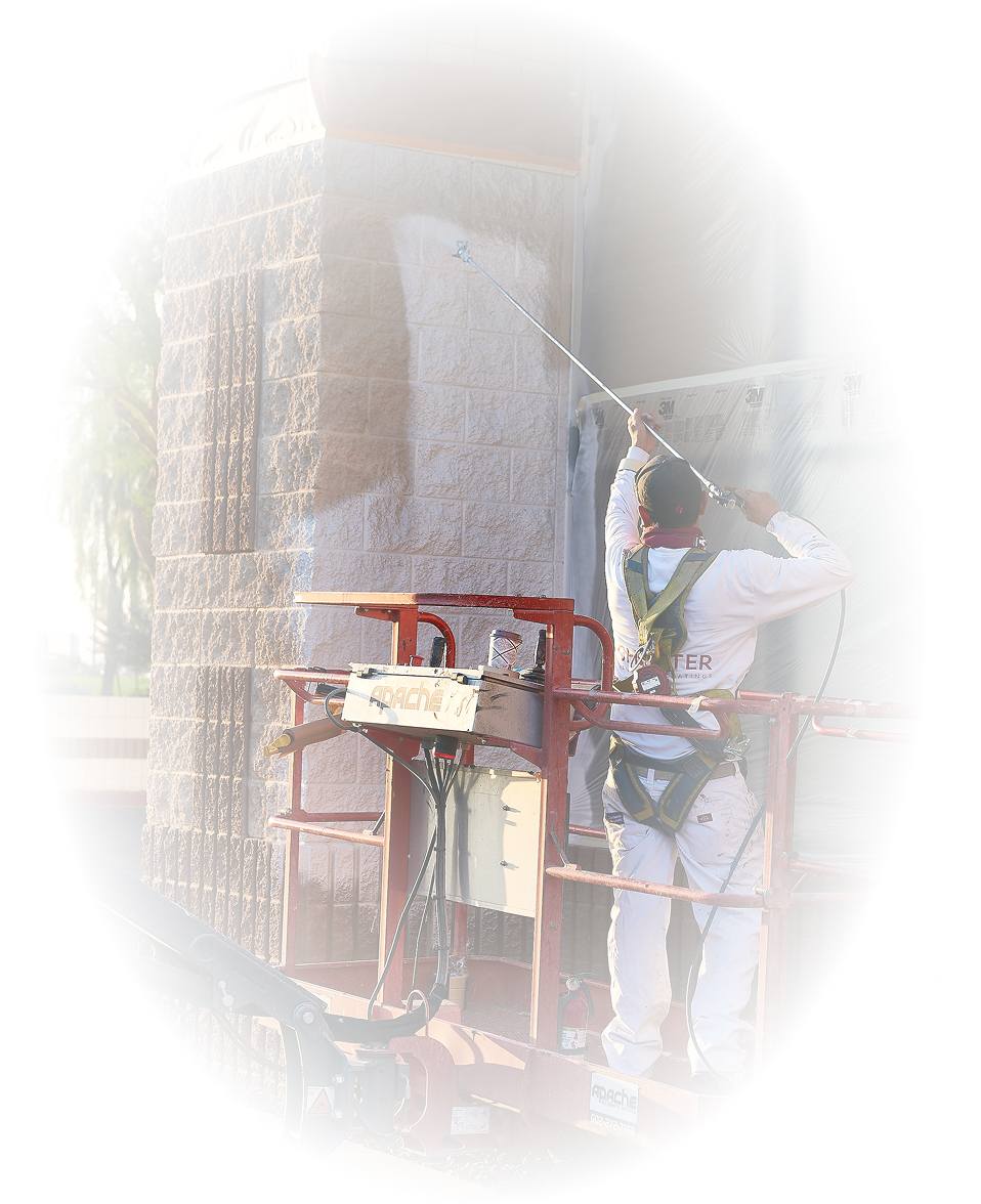 Professional painter applying exterior paint to commercial building