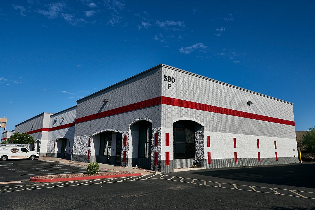Commercial warehouse building exterior with parking lot and modern facade