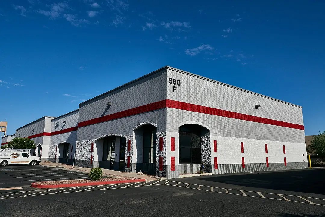 Commercial warehouse building exterior with parking lot and modern facade